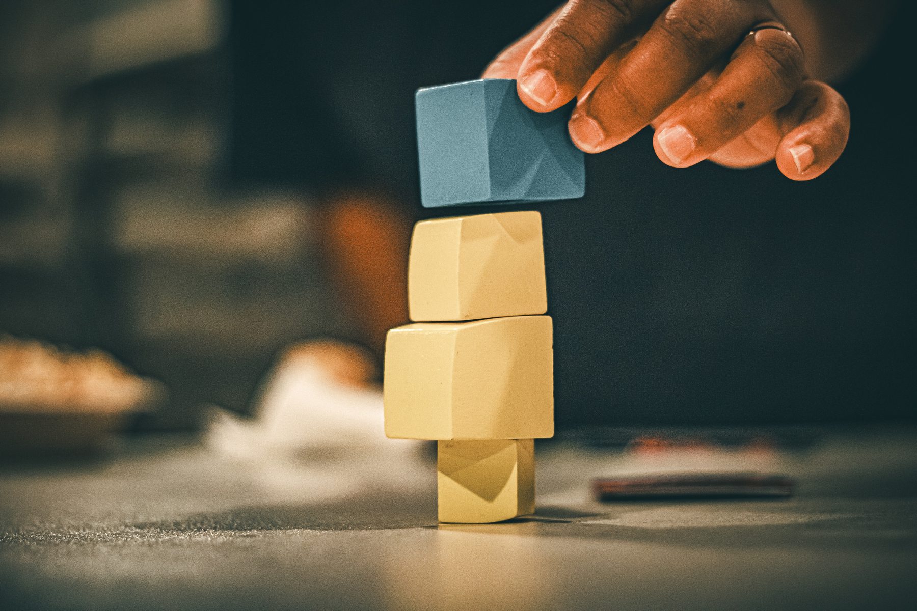 A hand stacking blocks